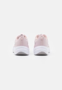 Zapatillas deportivas rosas con una parte superior de textil suave, collar acolchado y suela de goma blanca. Cuenta con un tirador en el talón para facilitar su uso.