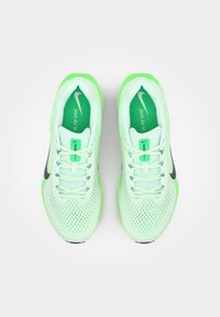 Nike løbesko i lys grøn mesh med sorte detaljer. Funktioner inkluderer en afrundet tå, åndbart overlæder og flade snørebånd.