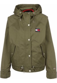 Oliwkowa kurtka z kapturem wykonana z trwałego materiału, z dwiema przednimi kieszeniami, zatrzaskami, ściągaczem na dole oraz naszywką z logo Tommy Jeans.