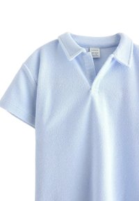 Jasnoniebieska koszulka polo wykonana z miękkiej, textured tkaniny, z kołnierzykiem i krótkimi rękawami. Posiada zapięcie na guziki i metkę marki.