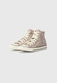 Höga sneakers i beige med ett ormskinnsmönster, krämfärgade snörningar och en kontrasterande svart gummisula. Texturerad tygöverdela.