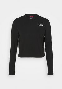 Svart långärmad cropped t-shirt i bomull, med rund hals och en liten vit logotyp på vänster bröst. Slät textur.