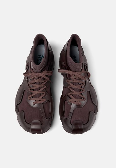 Sleek, burgundy sneakers featuring a rubberized upper, textured mesh panels, round laces, and padded collar for comfort.