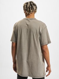 Graues, übergroßes T-Shirt aus einem Baumwoll-Mix. Es hat kurze Ärmel, einen Rundhalsausschnitt und eine lässige Silhouette mit glatter Textur.