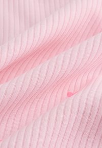 Tessuto rosa chiaro a coste con sottili strisce testurizzate; superficie liscia con lievi variazioni di tonalità; maglia fine.