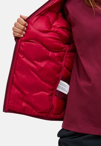 Red puffer jacket with a shiny, insulated interior. Features zip closure and an inner pocket. The exterior has a matte finish.