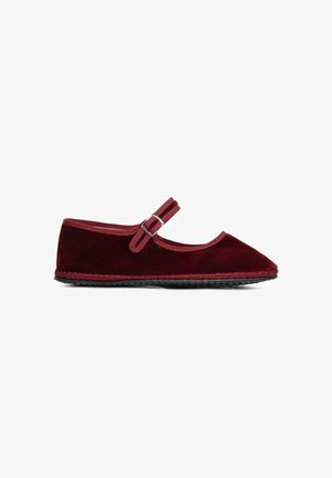 Chaussure plate Mary Jane en velours rouge avec un bout arrondi, présentant une bride décorative et une boucle, ainsi qu'une semelle en caoutchouc noire.