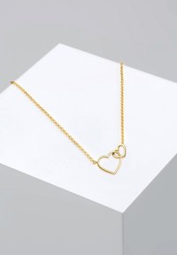 Guldkæde med to sammenkoblede hjertevedhæng, delikat kæde og glat finish. Enkel design og let vægt.
