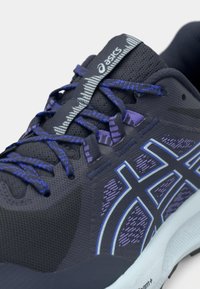 Asics løpesko i mørk marineblå og lys blå. Mesh-overdel med teksturerte detaljer, flate lisser og en polstret såle for komfort.