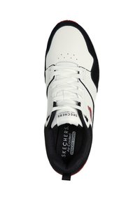 Baskets blanches et navy en cuir synthétique perforé, avec des accents rouges contrastants, des lacets ronds et une semelle intérieure rembourrée intitulée "Air Cooled Memory Foam."