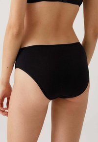 Zwarte naadloze hipsteronderbroek met een gladde textuur en volledige dekking, voorzien van een zachte tailleband en zonder zichtbare naden.