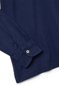 Marineblaues Langarmhemd mit Knopfmanschette, aus glattem Baumwollstoff. Verfügt über einen klassischen geraden Schnitt und minimalistische Nähakzente.