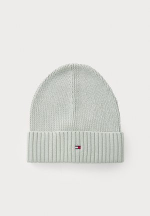 Bonnet tricoté vert clair avec un revers côtelé, comportant une petite étiquette logo rouge, blanche et bleue à l'avant. Texture lisse.