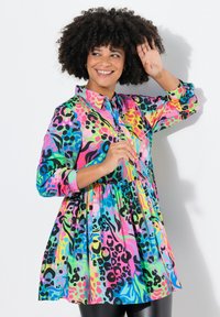 Chemise colorée à manches longues avec une taille froncée, présentant un mélange vibrant de motifs animaliers et abstraits dans des teintes de rose, bleu, vert et noir.