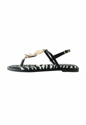 Flat black sandal with zebra-striped sole, gold seashell and starfish decoration, and ankle strap with gold buckle.
