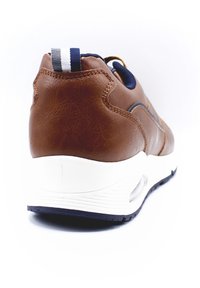 Baskets en cuir synthétique marron avec une semelle intermédiaire blanche et des accents marine. Présentent une surface texturée et une languette rayée au talon.