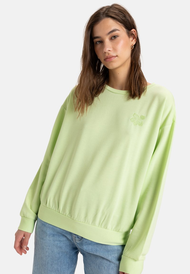 Light green sweatshirt with a round neckline, long sleeves, and a gathered hem. Features an embroidered flower design on the chest.