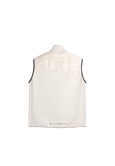 Gilet senza maniche color crema con schiena superiore imbottita, bordatura nera sulle aperture delle braccia e piccolo logo "J.LINDEBERG" vicino all'orlo inferiore.