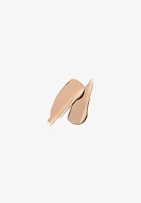 Deux échantillons de fond de teint beige avec une texture lisse et crémeuse sur un fond blanc.