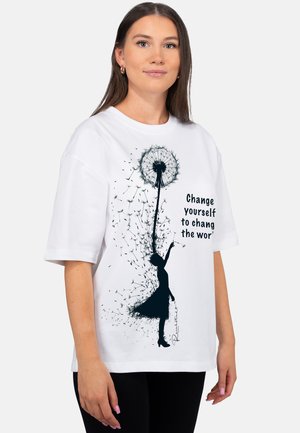 Young woman wearing white t-shirt with black silhouette of girl holding a dandelion, seeds blowing, and partial quote "Change yourself to chang the wor".