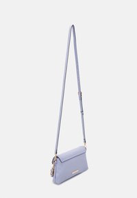 Light purple crossbody bag features a rectangular shape, smooth texture, a flap closure, and a gold-tone hardware accent.