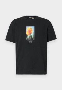 Sort bomulds T-shirt med et centralt blomstermotiv af orange blomster med grønne stilke, pyntet med tekst i hvid og blå.