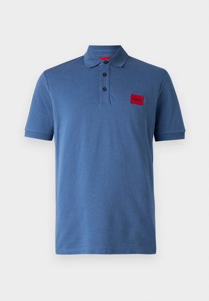 Blå polo skjorte lavet af glat stof. Har en krave, tre-knaps lukning og et rødt logo-patch på venstre bryst. Korte ærmer.