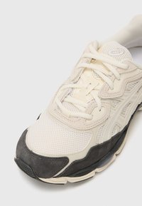 Heledad beez sneaker, mille- ja suede-paneelidega, tonalsete paeltega, vormitud disainiga ning musta kummi tallaga.