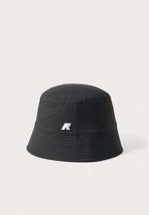 Sort bøllehat med et lille hvidt og gråt logo foran, vist mod en ensfarvet lysegrå baggrund.