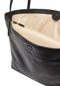 Borsa tote in pelle nera con texture a grana, tasca interna con zip dorata e fodera beige con un leggero motivo logo.