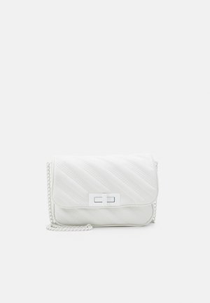 Petit sac bandoulière blanc matelassé avec fermoir à verrouillage tournant rectangulaire argenté et bandoulière chaîne argentée sur fond uni.
