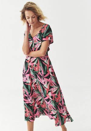 Robe florale en vert et rose, avec des manches courtes, un décolleté en V et une jupe fluide qui tombe sous le genou avec une coupe décontractée.