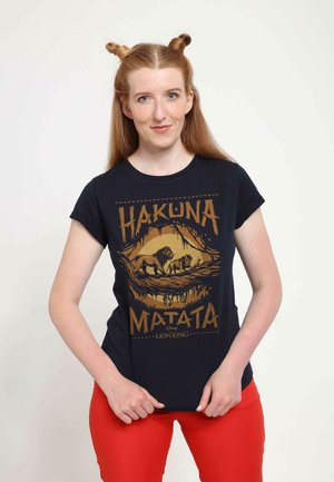 Černé bavlněné tričko s zlatým potiskem "Hakuna Matata" a dvěma siluetami lvů proti designu stromy; krátké rukávy, kulatý výstřih.