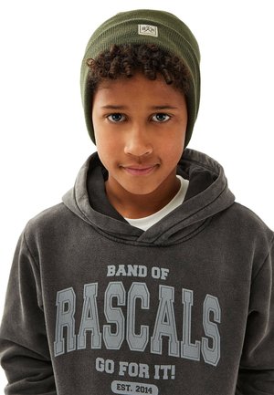 Grøn strikket hue med et logo-patch, parret med en mørkegrå hoodie med hvid og lysegrå tekst. Smagfuld, tætsiddende stil.