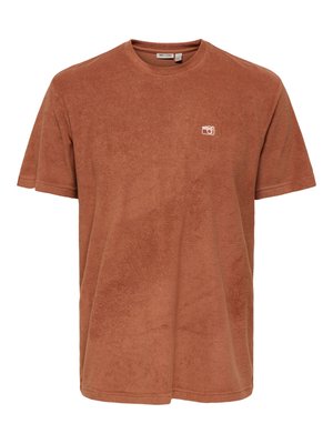 Brązowy t-shirt z frotty z krótkim rękawem, z okrągłym dekoltem i małą białą ikoną aparatu wyszywaną na lewej piersi.