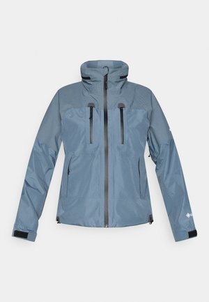 Μπλε αδιάβροχο μπουφάν από απαλό ύφασμα με ψηλό γιακά, δύο εμπρόσθιες τσέπες με φερμουάρ και μαύρες λεπτομέρειες στα μανίκια. Υφή στην περιοχή των ώμων.