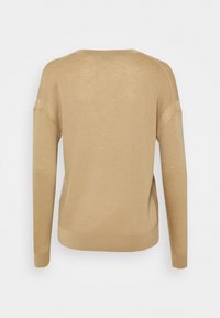 Pull en maille beige à manches longues vu de dos avec un col rond et un ourlet et des poignets côtelés.
