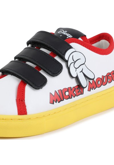 Valkoiset tennarit mustilla tarranauhalla, punaisia yksityiskohtia, keltainen pohja ja Mickey Mouse -grafiikka rauhanmerkillä sivussa.