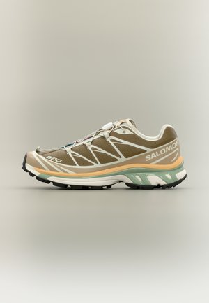 Μπεζ και πράσινο παπούτσι για τρέξιμο σε μονοπάτια Salomon με λευκές λεπτομέρειες, γρήγορο σύστημα κορδονιών και υφασμένη λαστιχένια σόλα για πρόσφυση, πλάγια όψη.