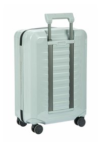 Valigia rigida di colore verde menta chiaro, caratterizzata da un design elegante, texture a righe orizzontali, manico telescopico e quattro ruote nere.