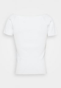 Vit ribbad kortärmad topp med fyrkantig halsringning, figurnära design och mjuk textur. Ingen synlig hårdvara eller mönster.