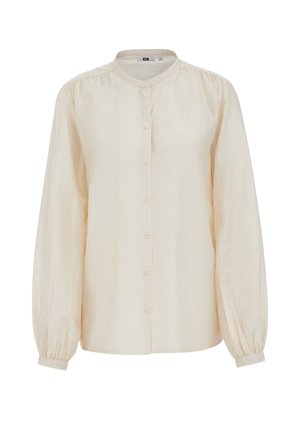 Kremasta bluza dugih rukava s okruglim izrezom, prednjim kopčanjem na gumbe, lagano napuhanih rukava i manžetnama s gumbima.