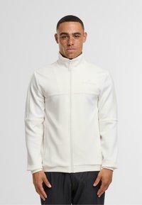 Valge lukuga jakker, mis on valmistatud pehmest materjalist, kõrge krae, kaks esist pocketit ja tekstureeritud külgpaneelid.