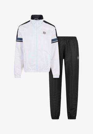 Giacca bianca con zip, dettagli neri e teal, abbinata a pantaloni neri. Entrambi realizzati in tessuto leggero, con polsini e vita elasticizzati.