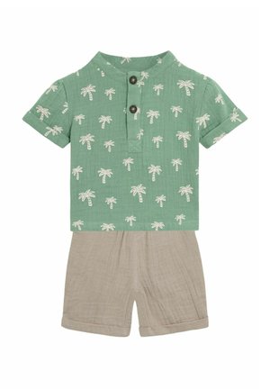 Kortærmet grøn skjorte med hvidt palme-træ mønster, knapdetalje, parret med beige shorts lavet af letvægtsstof.