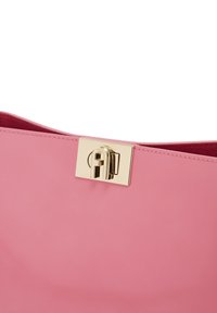 Borsa a tracolla rosa lucida con una texture liscia e una chiusura in metallo dorato. Presenta un'apertura ampia con una fodera interna di una tonalità di rosa più scura.