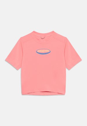 Camiseta de manga corta color coral rosa con cuello redondo y logo amarillo de "patagonia" en un óvalo azul centrado en el pecho.