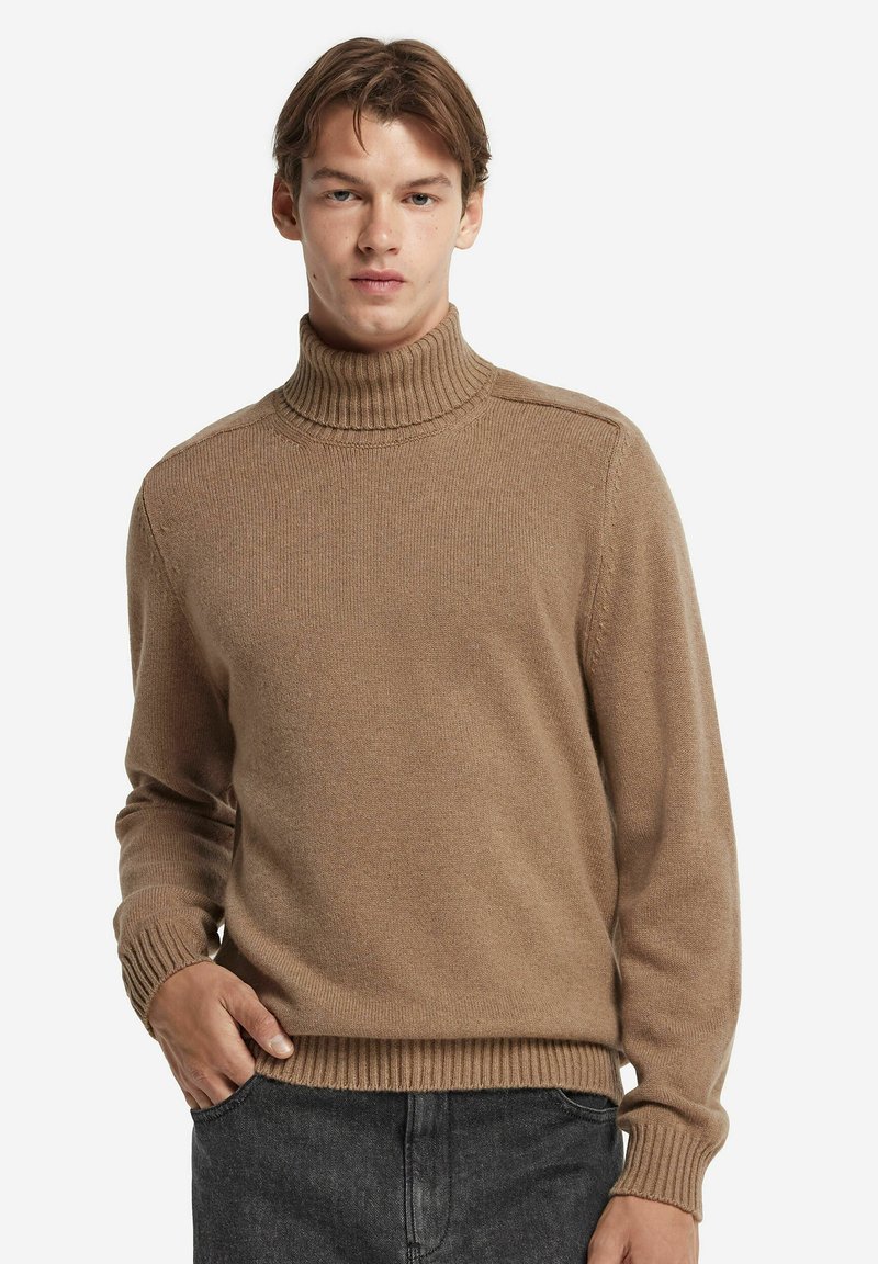 Ljusbrun polo för med ribbade manschetter och krage, tillverkad av ett mjukt, texturerat material. Enkel design, figurnära silhuett.