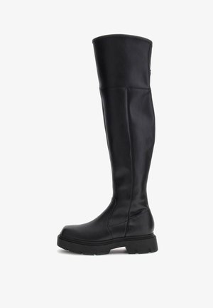Stivali neri in pelle al ginocchio con suola spessa, texture liscia e dettagli di cucitura sottili lungo l'asta. Design della punta angolare.