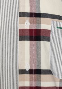 Kariertes Hemd mit gemusterten Längs- und Querstreifen, hauptsächlich in Beige, Schwarz und Rot, mit einer Brusttasche und leichtem Stoff. 